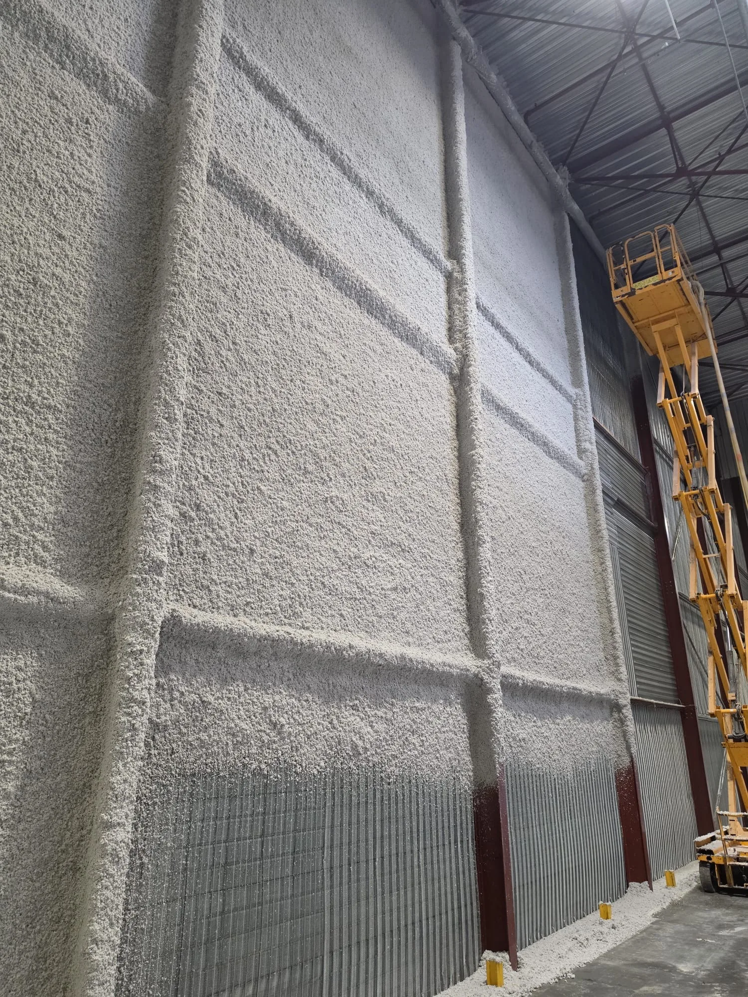Application du flocage fibreux coupe-feu avec nacelle dans un bâtiment logistique à Lesquin
